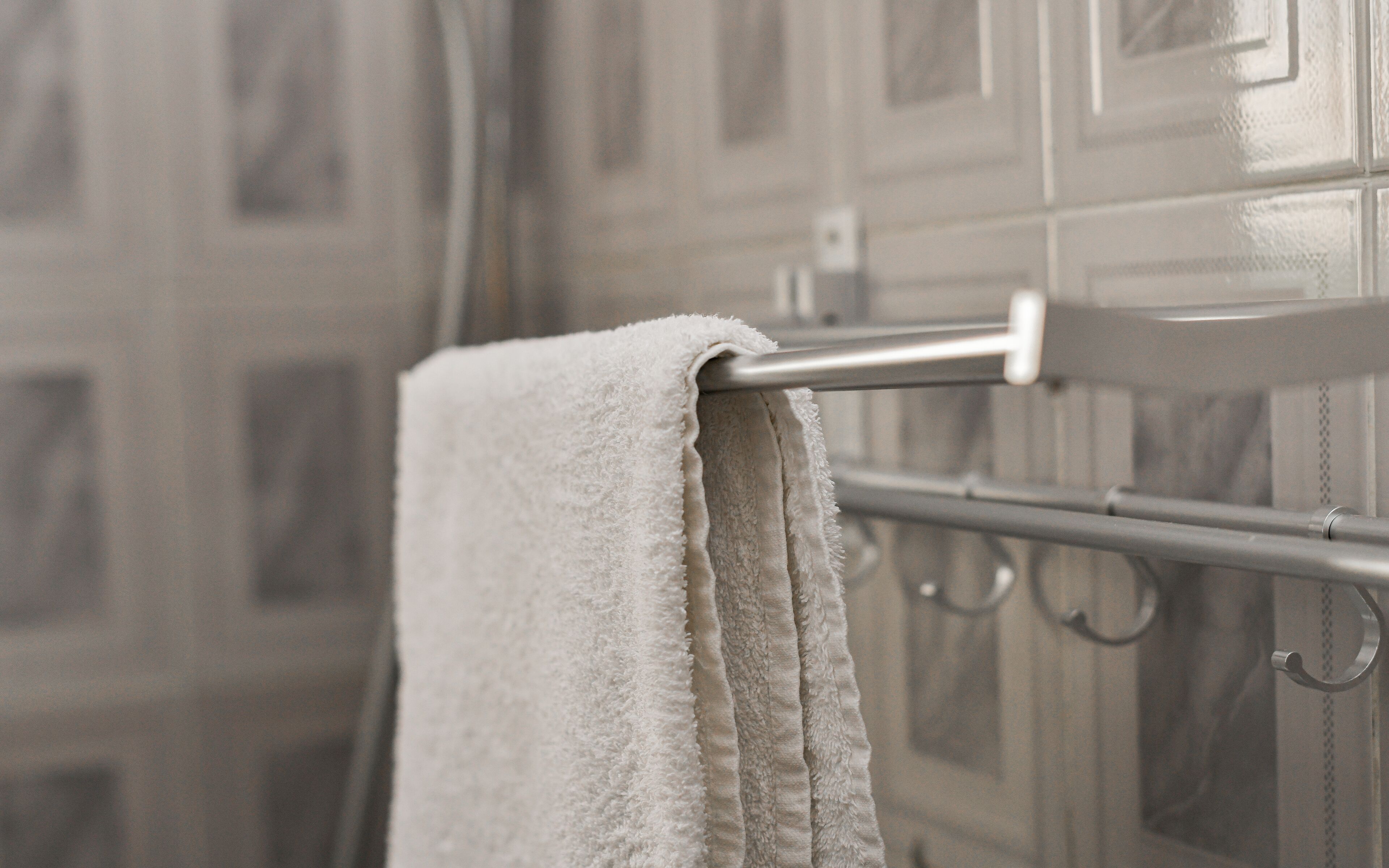 A bathroom with a towel hanging on a metal towel rack.