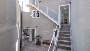 A multi-level apartment with a staircase, a kitchen area, and a small seating area. - Villa Sophia (São Paulo)