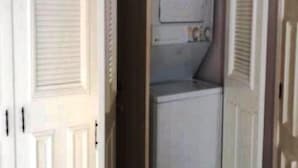 A narrow hallway with a laundry room featuring a washing machine and a small window. - Casa en Marina Cid (Mazatlán)