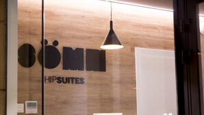 A hotel sign with the name 'HIPSUITES' and a modern pendant light.