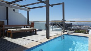 A pool area with a wooden deck, a bench, and a view of the port. - 46 Loader De Waterkant (Cape Town)