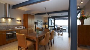 A modern kitchen with a dining area, large windows, and a view of the city. - 46 Loader De Waterkant (Cape Town)