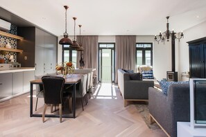 A modern living space with a dining area, sofa, and a fireplace.