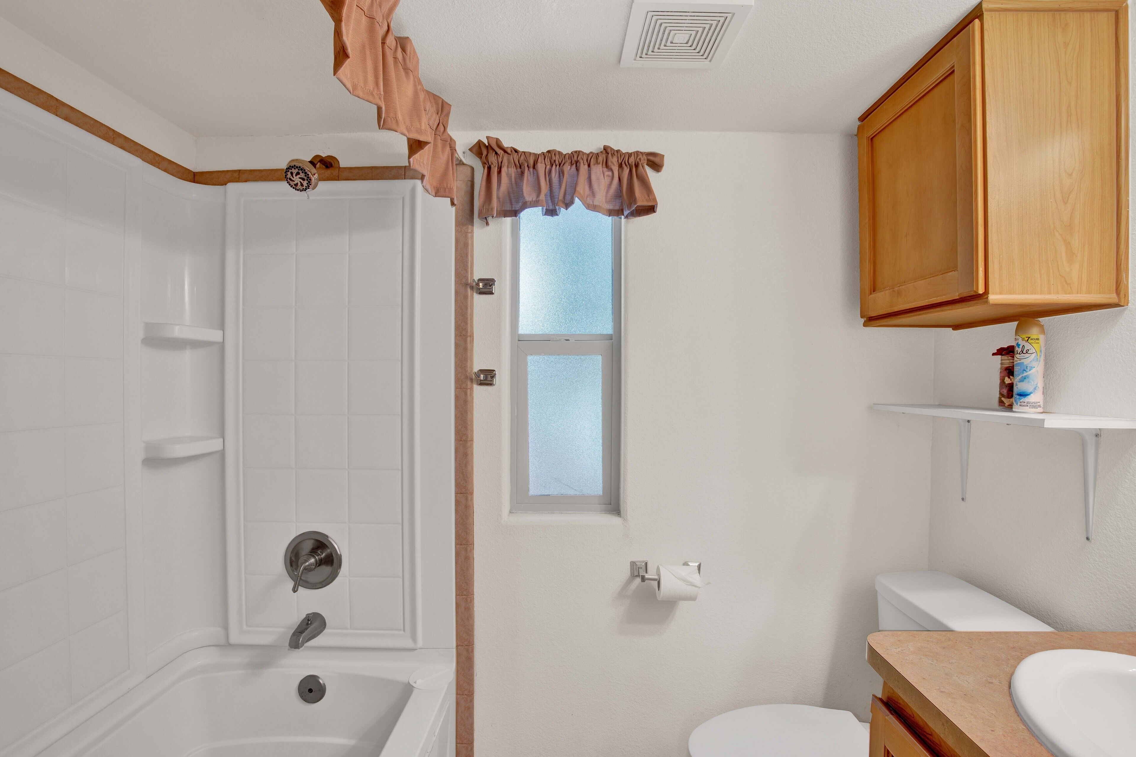 A bathroom with a bathtub, toilet, and sink.
