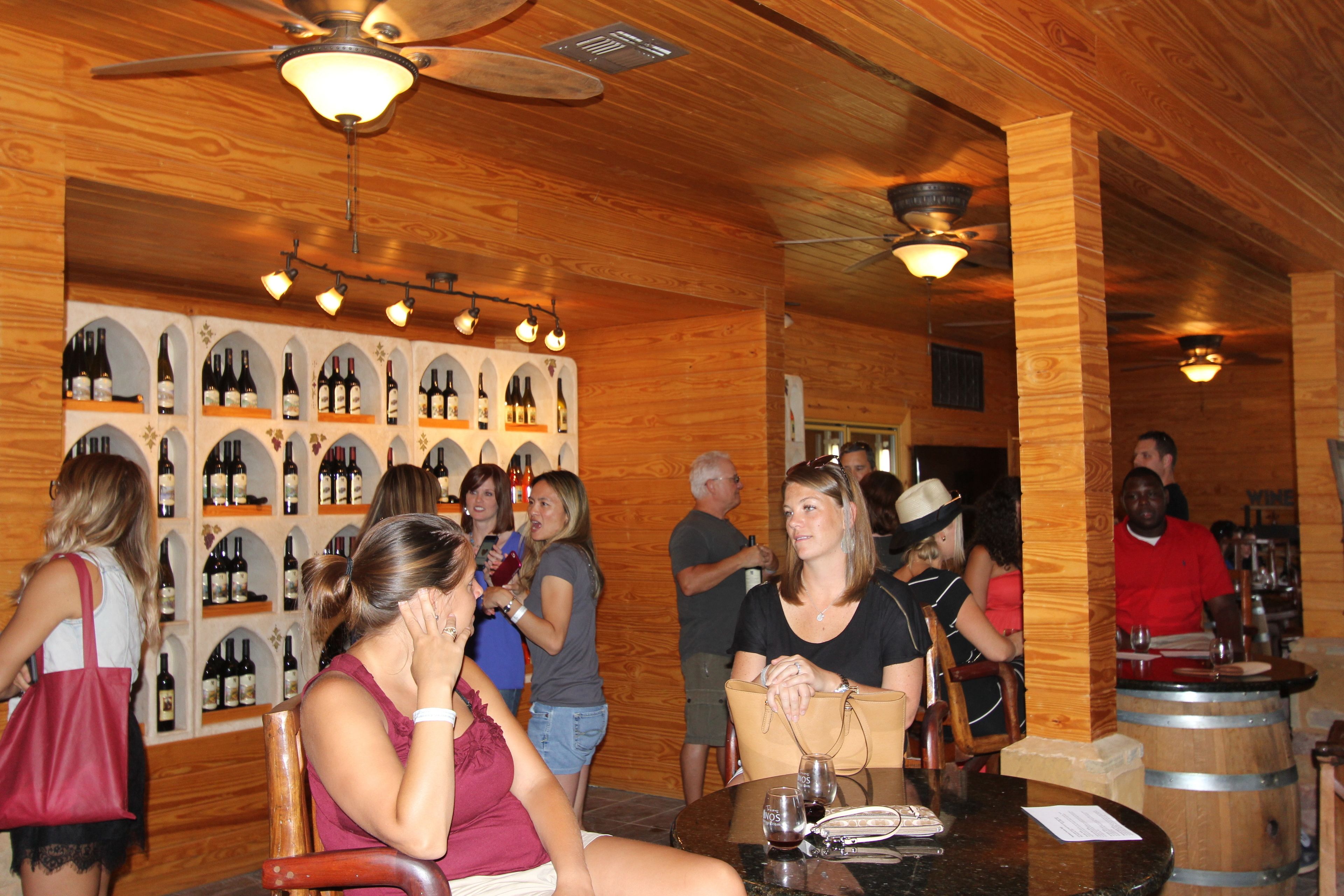A wooden interior with wine racks, tables, and chairs.