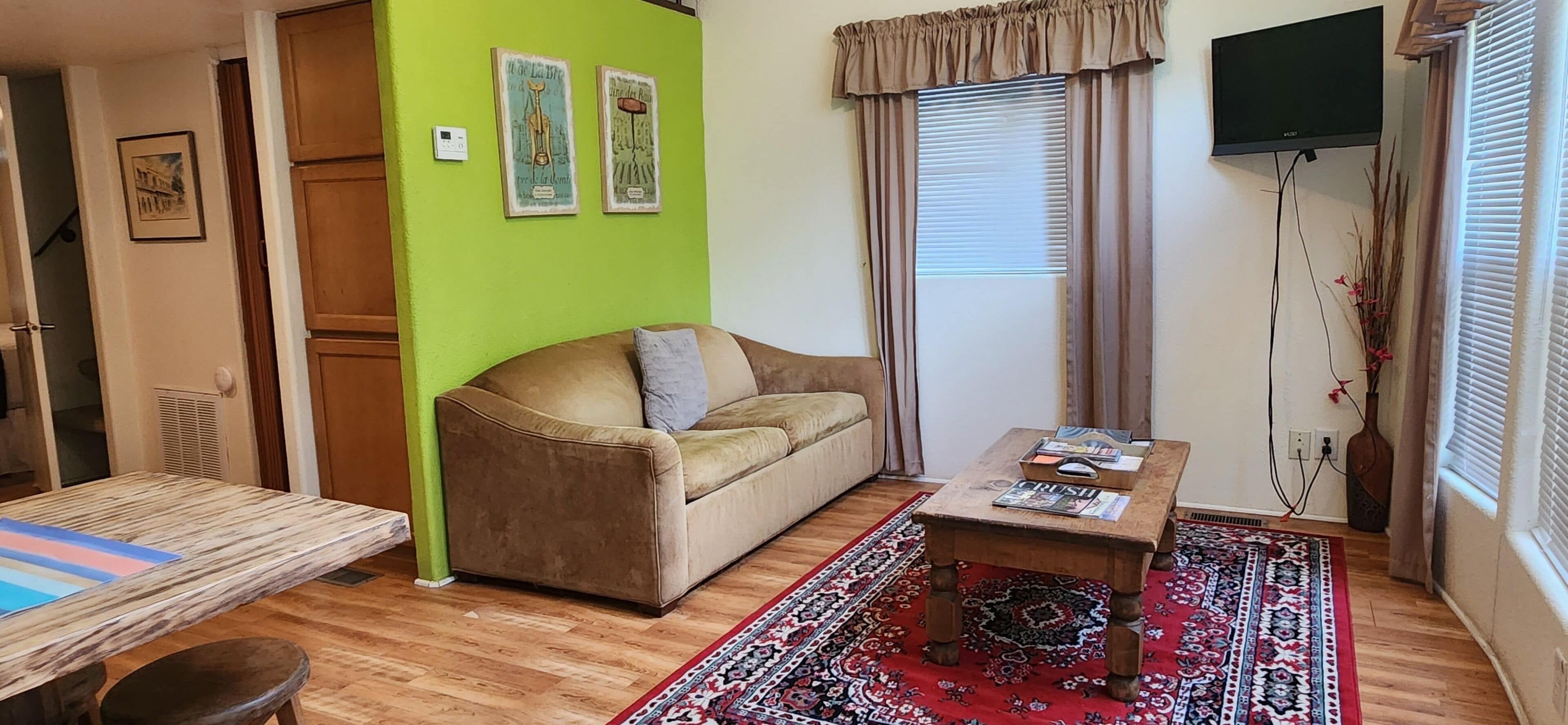 Una sala de estar acogedora con un sofá, una mesa de centro y una alfombra estampada.