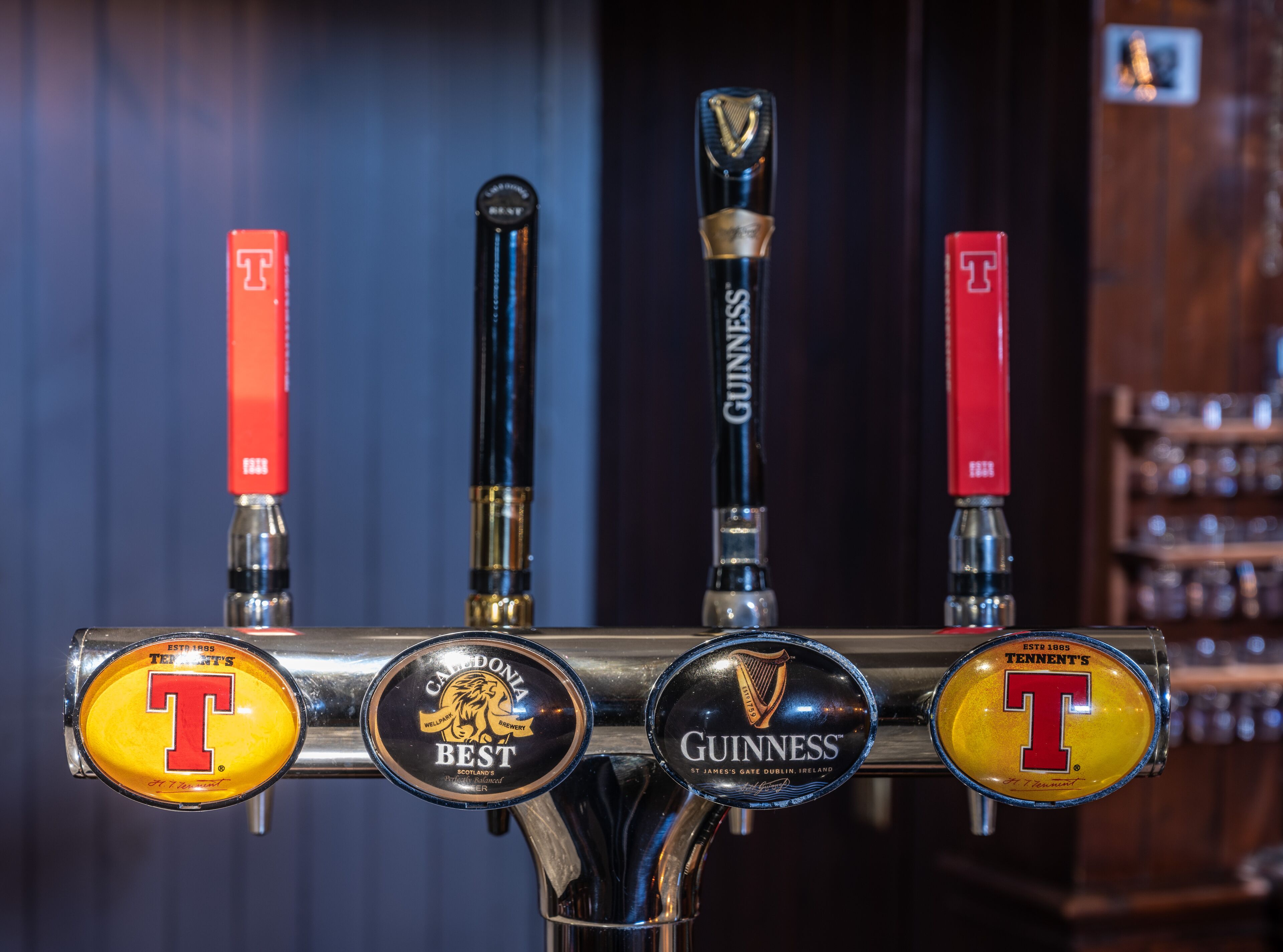 Een biertappinstallatie met vier verschillende tappunten, waaronder merken zoals Tennent's, Best en Guinness.