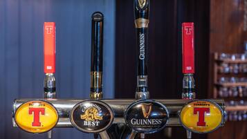 Een biertappinstallatie met vier verschillende tappunten, waaronder merken zoals Tennent's, Best en Guinness.