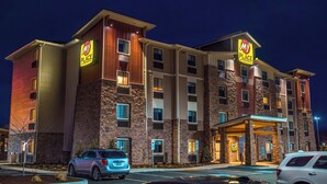 Un hôtel à plusieurs étages, reconnaissable à son enseigne « My Place », doté d’une entrée couverte et d’un parking où sont stationnées des voitures.