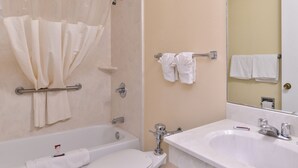 A bathroom with a bathtub, toilet, and sink.