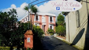 A hotel entrance with a sign for Hotel S. Carlos Parking. - Albergo San Carlo (Massa)
