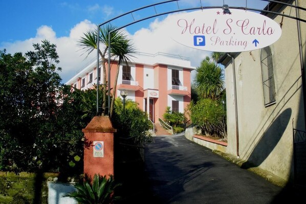 Hoteleingang mit Schild für Hotel S. Carlos Parken.