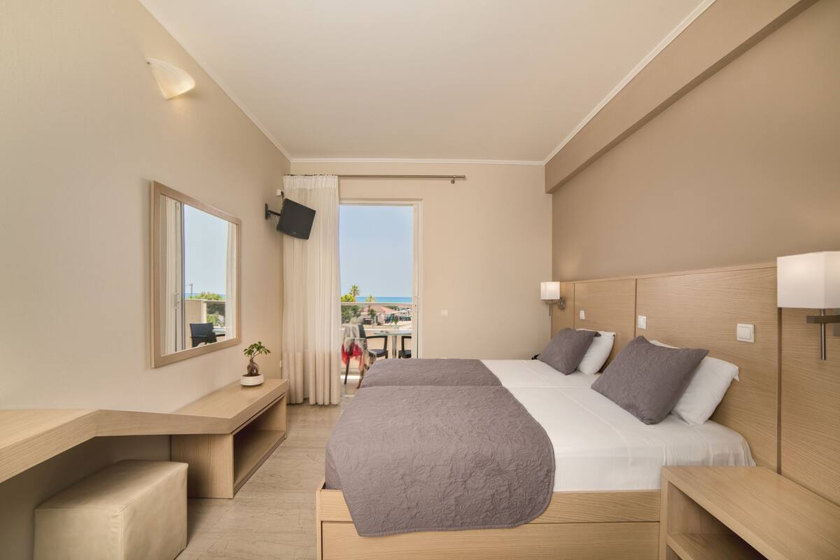 Une chambre d’hôtel moderne équipée d’un grand lit, d’un bureau, d’une chaise et d’une télévision.