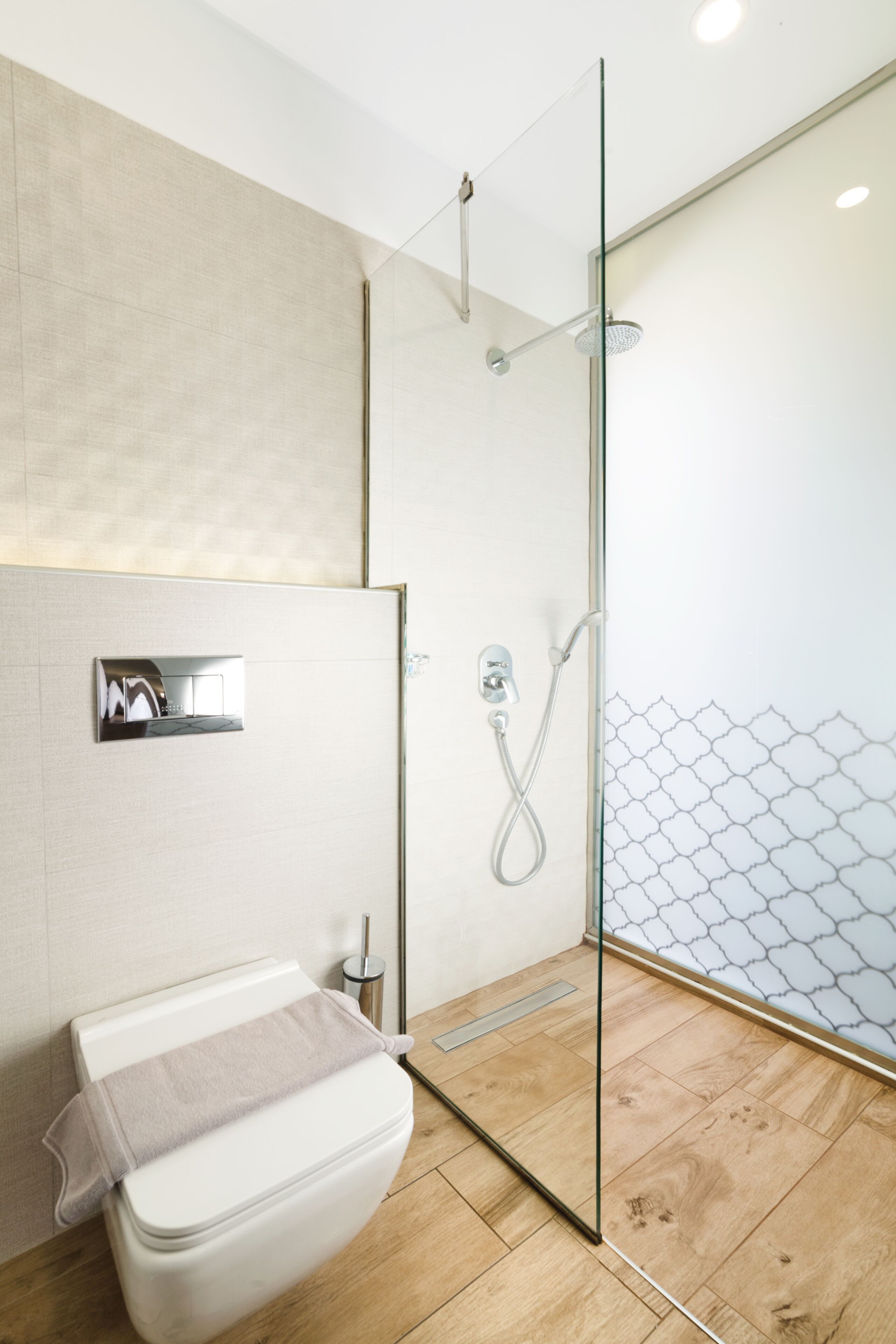 Ein modernes Badezimmer mit Duschkabine aus Glas, Toilette und Waschbecken.