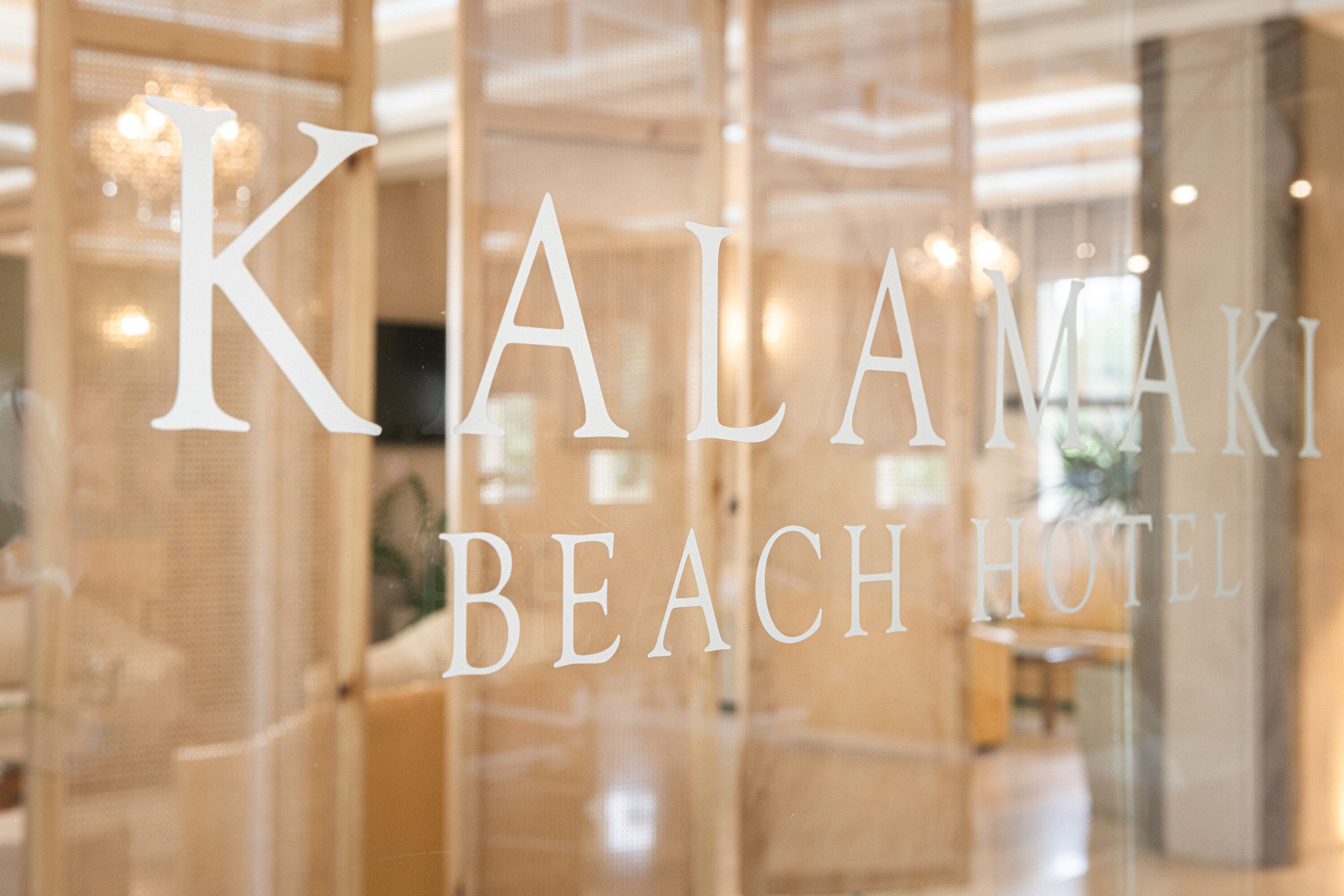 A hotel sign with the name "KALAMAKI BEACH HOTEL" in large letters.