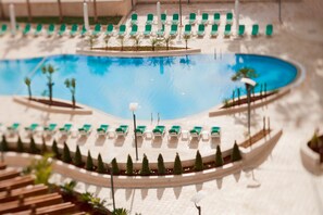 A pool area with lounge chairs and a small boat. - Millennium Palestine Ramallah (Ramallah)