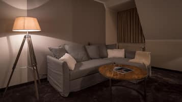 A modern living room with a grey sofa, a round coffee table, and a floor lamp.