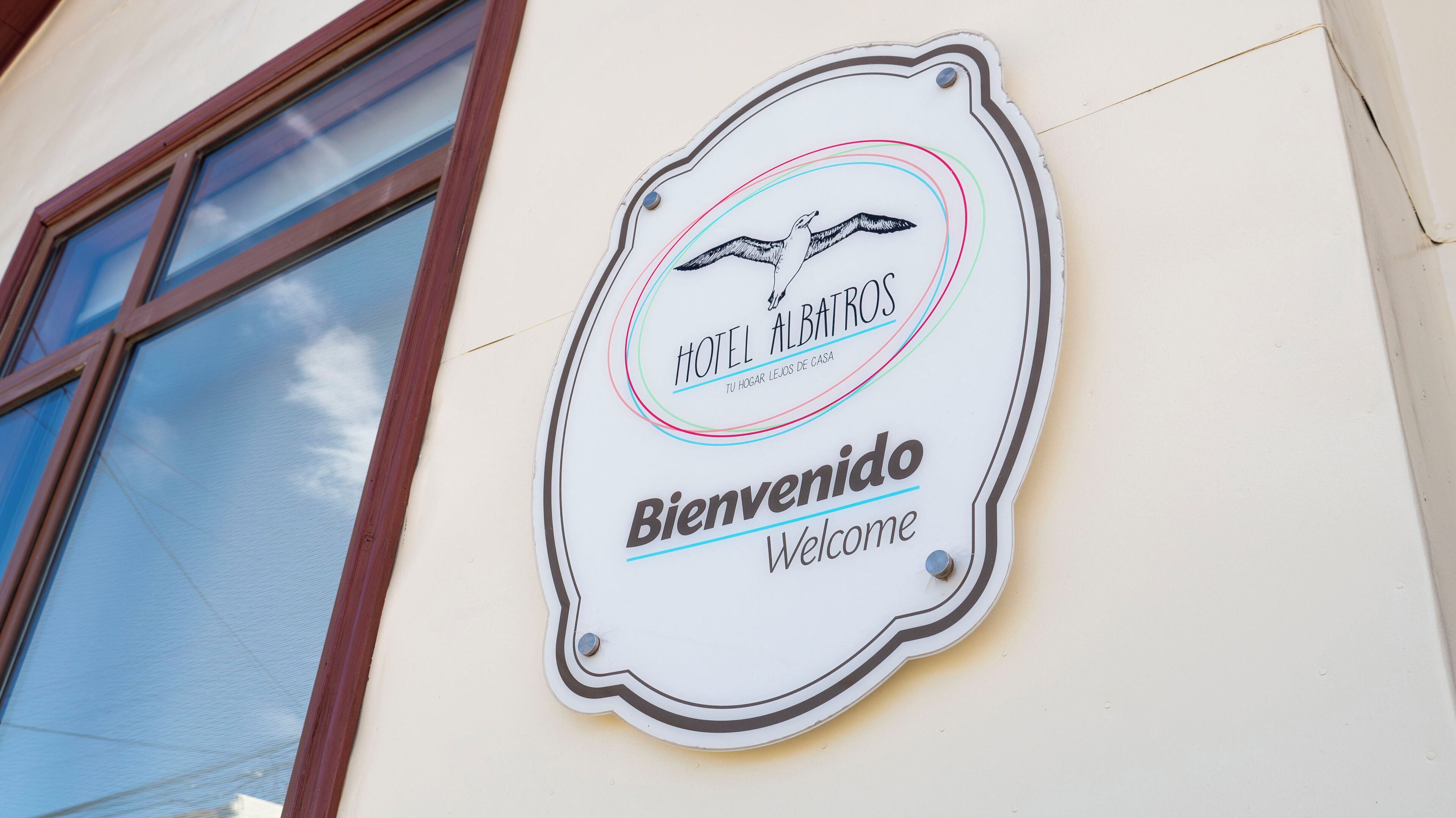 A sign for Hotel Albatros with a bird illustration and the words "Bienvenido" and "Welcome".
