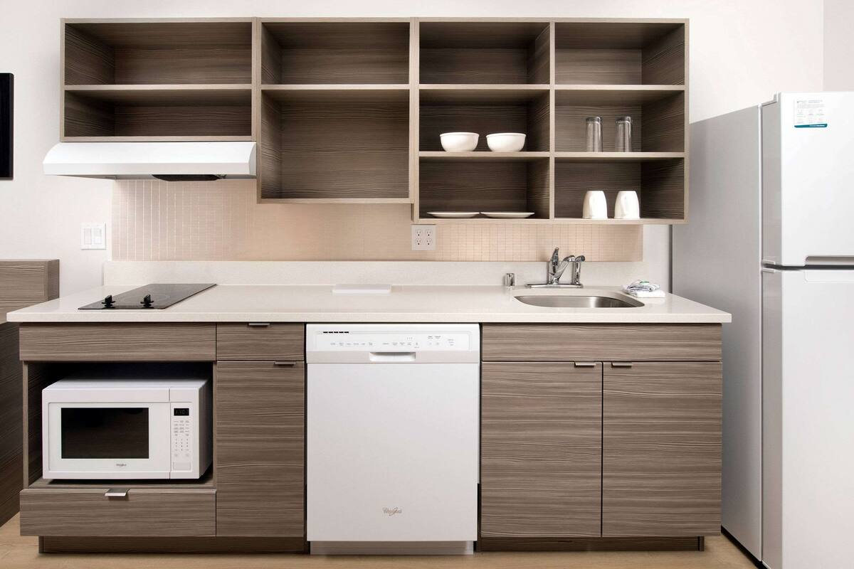 A modern kitchen with built-in appliances, wooden cabinets, and a countertop.