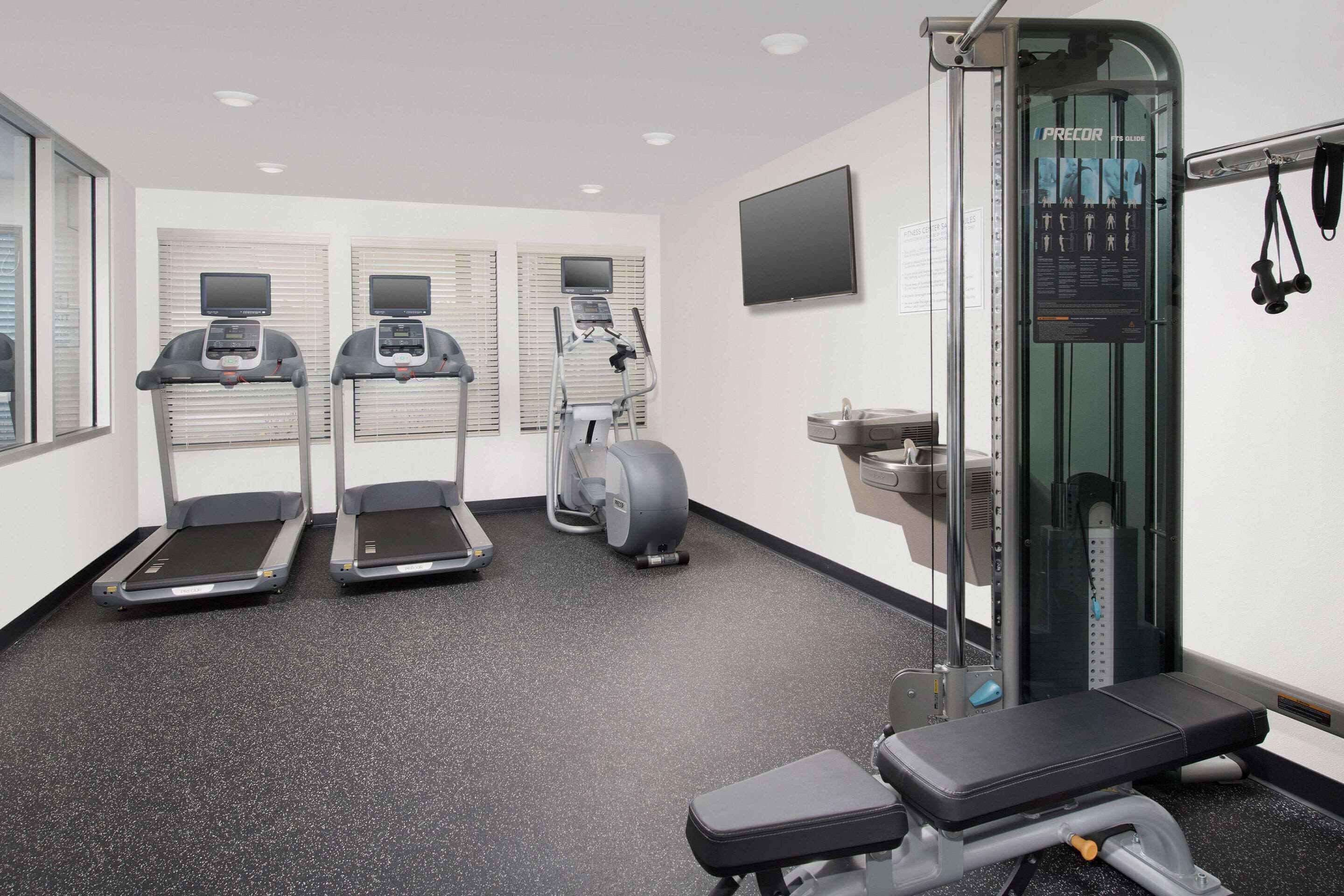 A gym with treadmills, an elliptical, and a weight machine.