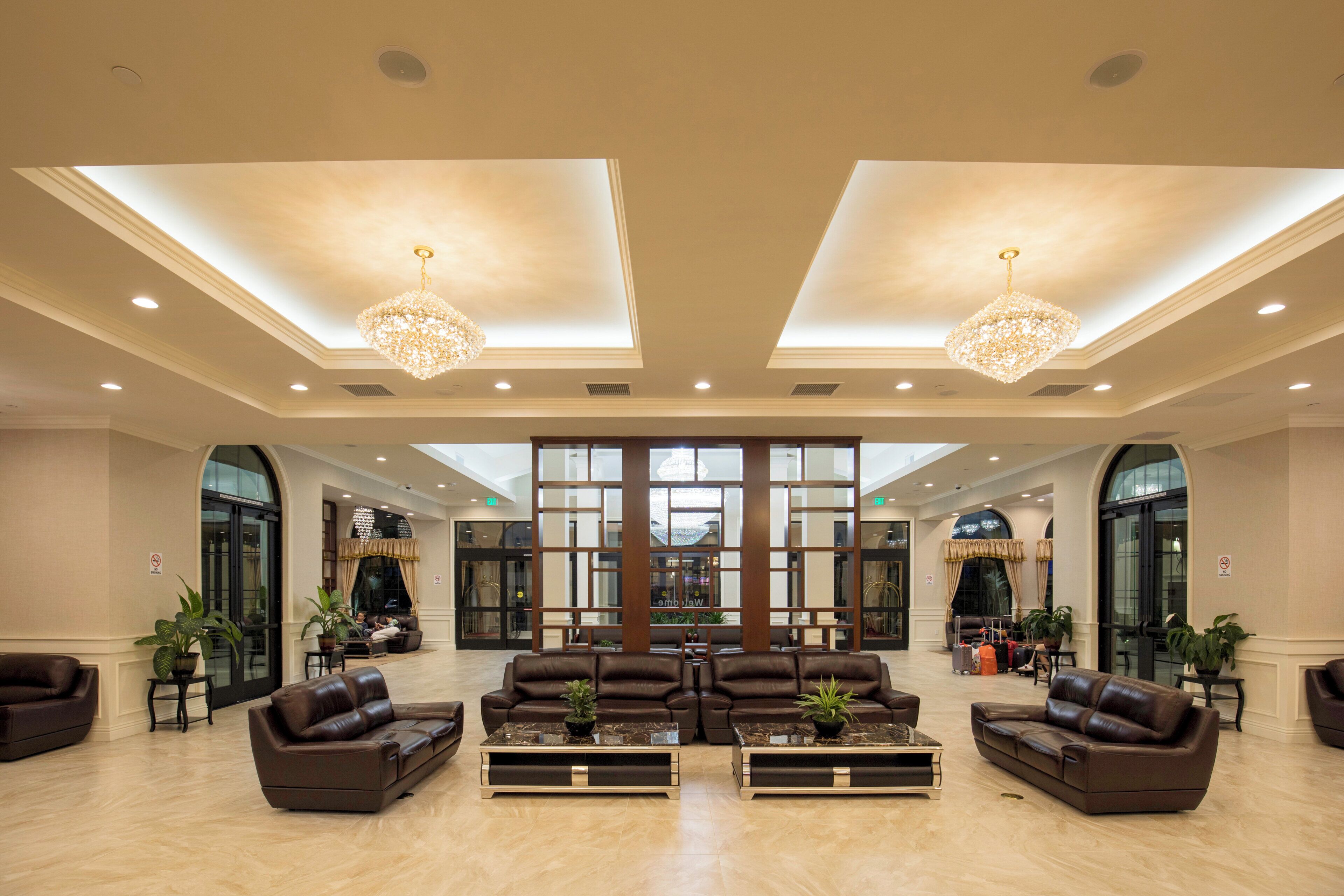 A spacious lobby with leather sofas, a central coffee table, and a large window.