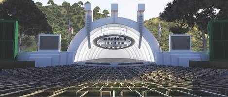 A large, modern auditorium with tiered seating and a central stage.