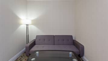 Una habitación con un sofá y una mesa de centro de vidrio.