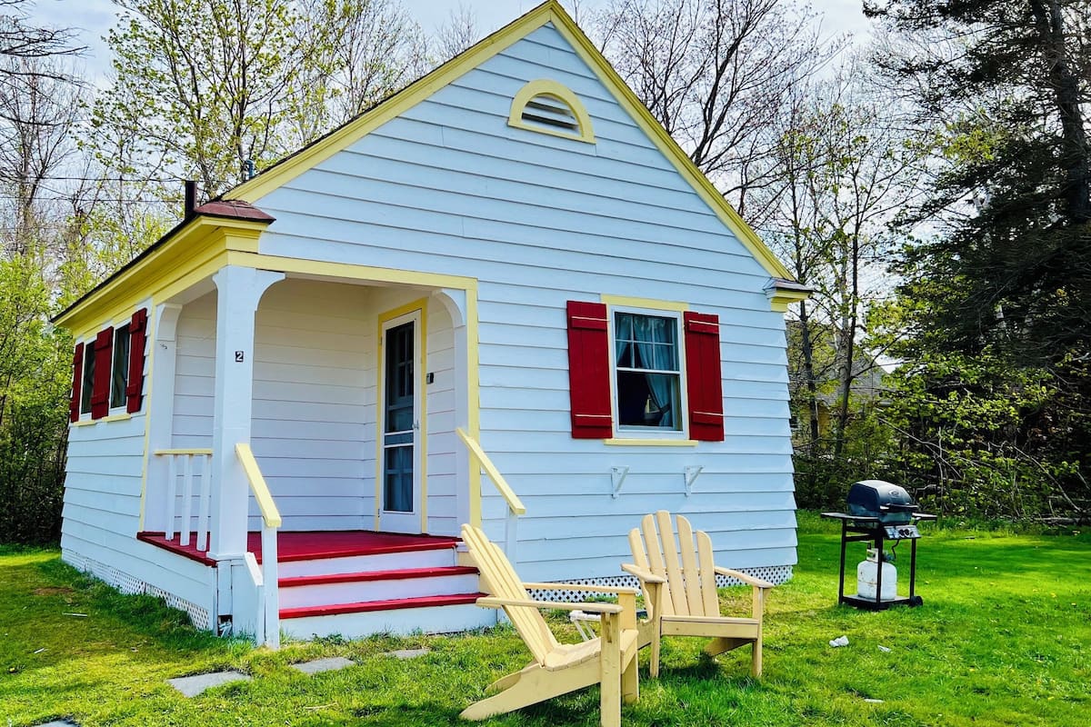 A small, single-story house with a porch, numbered 2, and a red chimney.