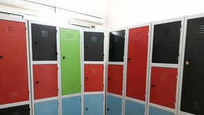 A row of lockers with multiple colors including red, green, blue, and black. - Hostel Brazil Backpackers (Guarujá)