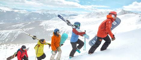 A group of skiers ascending a snowy mountain with a clear sky.