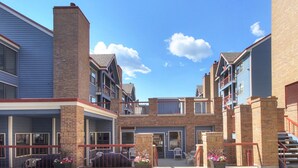 A multi-story building with a central courtyard, featuring balconies, a covered patio area, and brick construction.