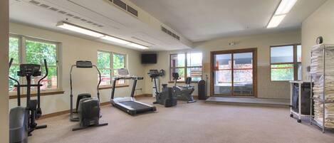A gym with treadmills, elliptical machines, and a stationary bike.