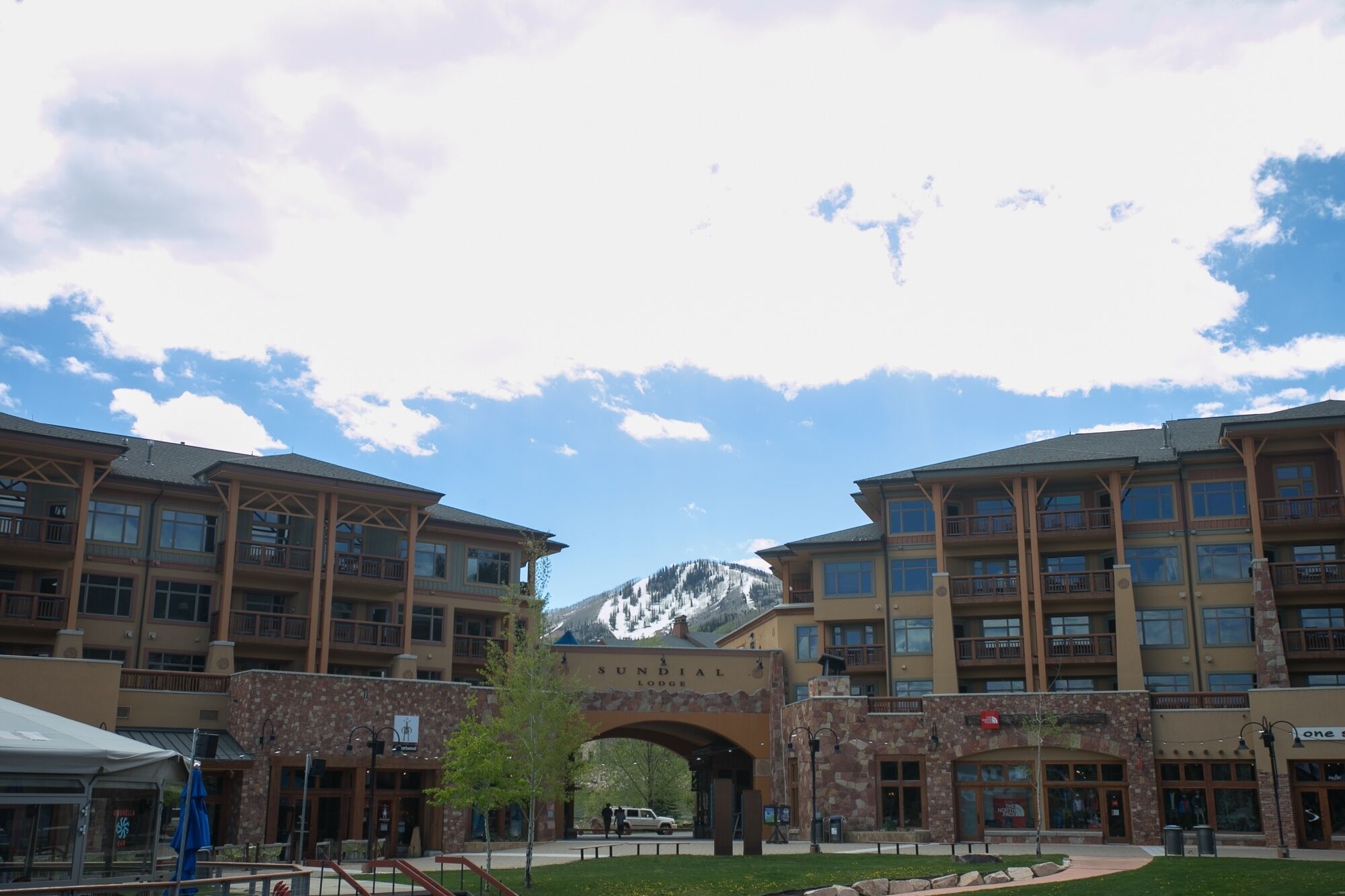 A lodge with a stone archway, multiple floors, and a mountain in the background.