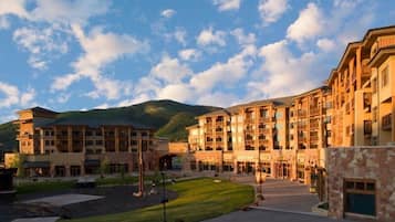 A multi-story hotel with a central courtyard, stone facade, and mountain views.