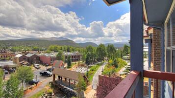 A view of a town with buildings, a river, and mountains in the background.
