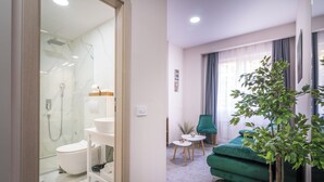 A modern bathroom with a glass shower enclosure, a toilet, and a sink.