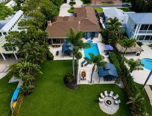 A residential property with a swimming pool, outdoor seating, and a fire pit.