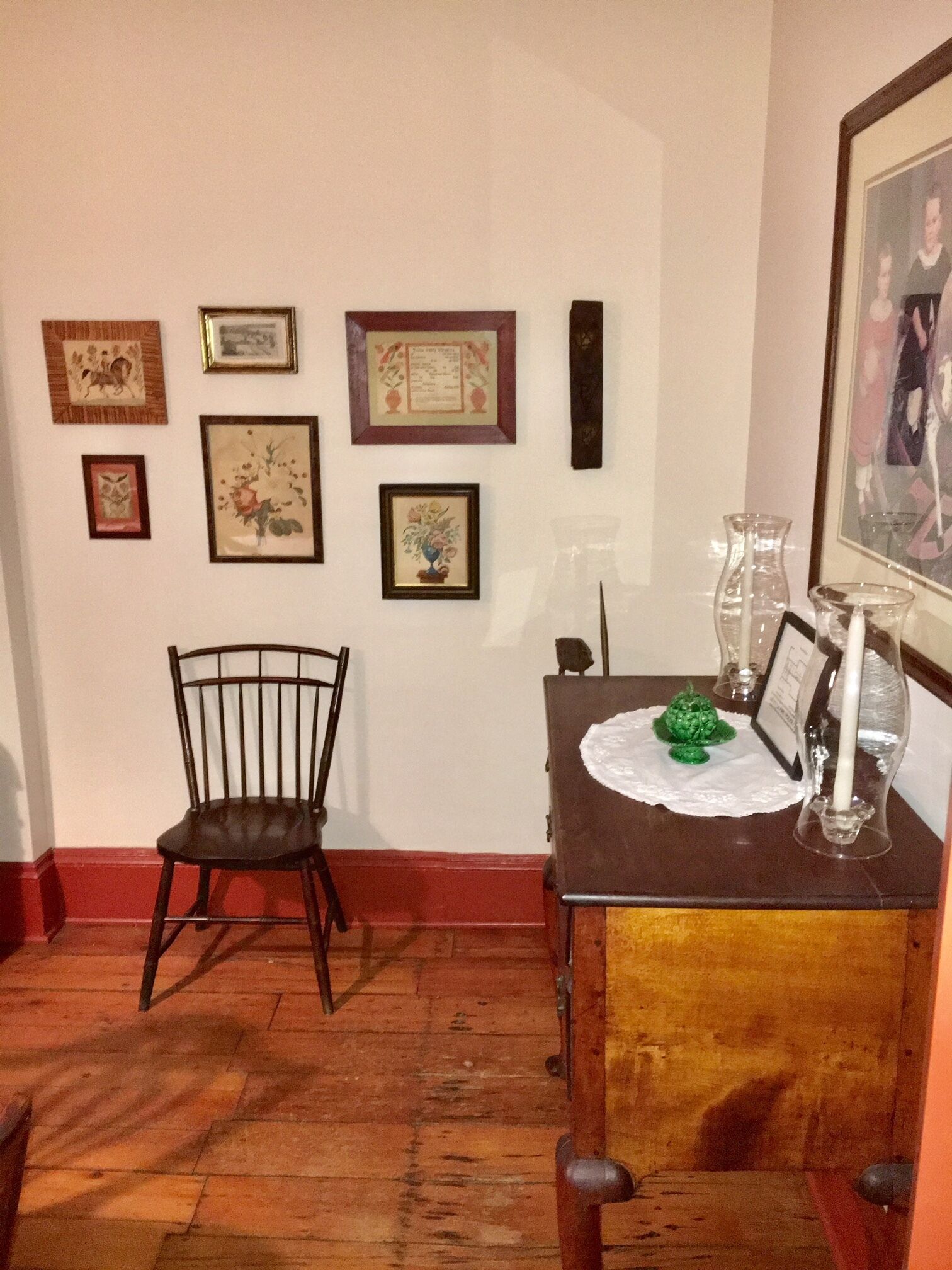 A dining area with a wooden table, chairs, and framed artwork on the wall.
