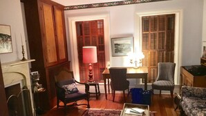 A traditional living room with wooden flooring, a fireplace, a red rug, and two armchairs. - View from Quality Hill overlooking historic district, quick walk to downtown (Galena)