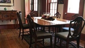 A dining room with a wooden table, chairs, a chandelier, and a large window. - View from Quality Hill overlooking historic district, quick walk to downtown (Galena)