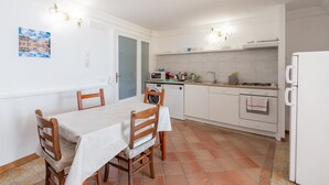 Una cocina compacta con una mesa de comedor, sillas, lavadora y refrigerador.
