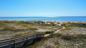 A beach with a wooden boardwalk leading to the water. - Fall is spectacular on the Cape! Book your trip now (Port St Joe)