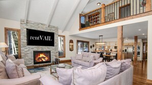 A spacious living room with a fireplace, a dining area, and a kitchen. - Glen Lyon Lodge | Spacious 5BR Vail Home, Cascade Lift #20 (Vail)