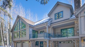 A two-story house with a stone facade, large windows, and a garage. - Glen Lyon Lodge | Spacious 5BR Vail Home, Cascade Lift #20 (Vail)