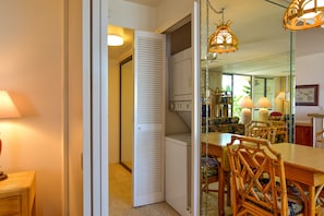 Enjoy meals in this cozy dining area with a table and chairs, a hanging light fixture, and a mirror.