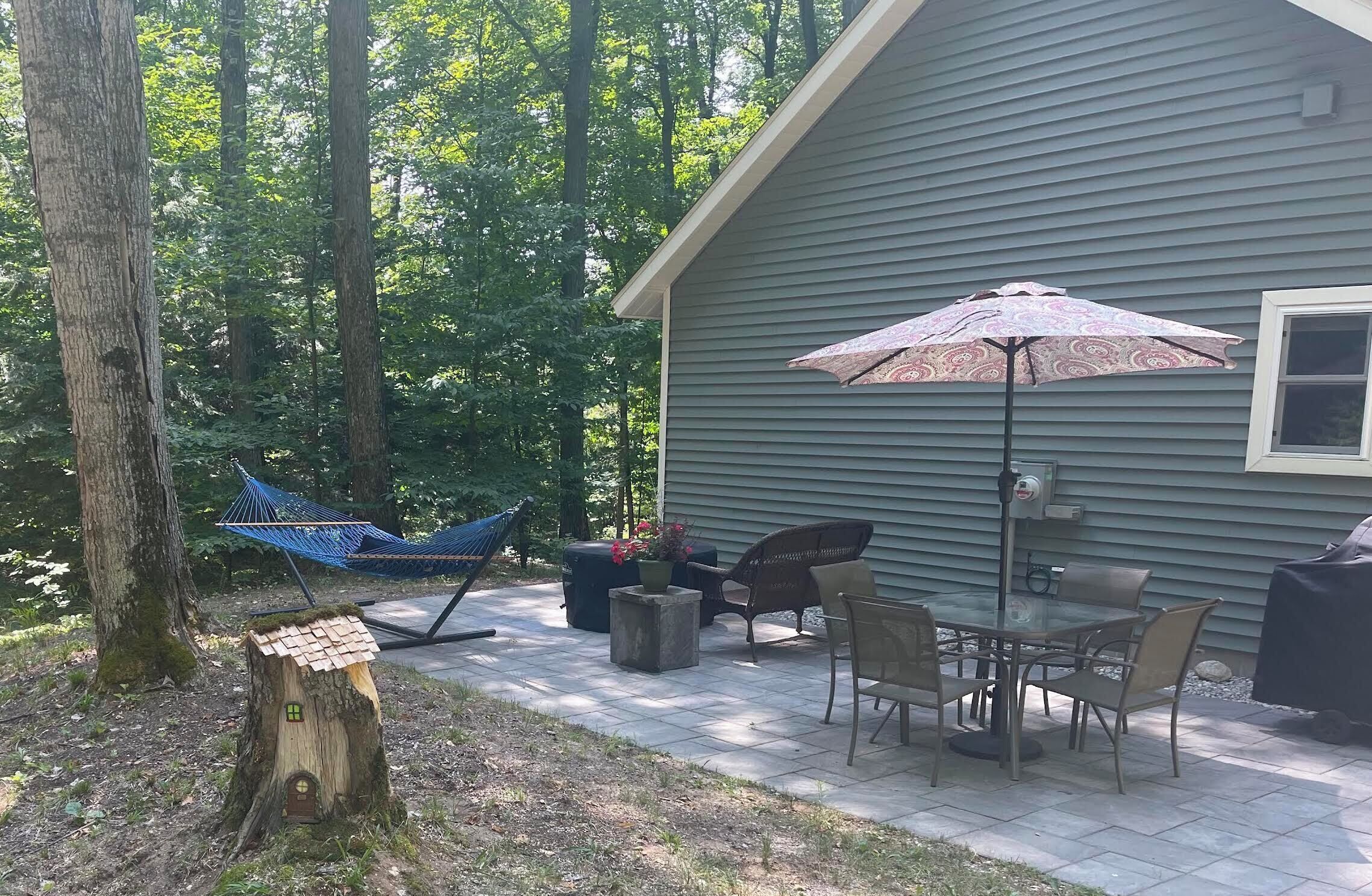 Outdoor patio to relax on with a fire table, hammock, and a grill.