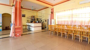 Um quarto amplo com área de jantar, cozinha e ventilador de teto.
