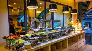 A buffet with various food items and a person serving. - Ritzy Boutique Hotel Da Nang (Da Nang)