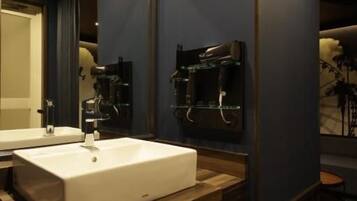 Een badkamer met een groot wit wastafelmeubel, een houten opbergkast en een spiegel.
