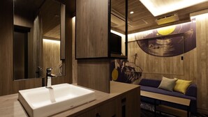 Une salle de bain moderne avec un grand miroir, un lavabo blanc et un meuble-lavabo en bois.